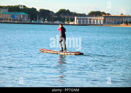 Weymouth. 24. September 2018. UK Wetter: Ein junger Mann paddel-Boards in Weymouth Bay in der frühen Morgensonne Credit: stuart Hartmut Ost/Alamy leben Nachrichten Stockfoto