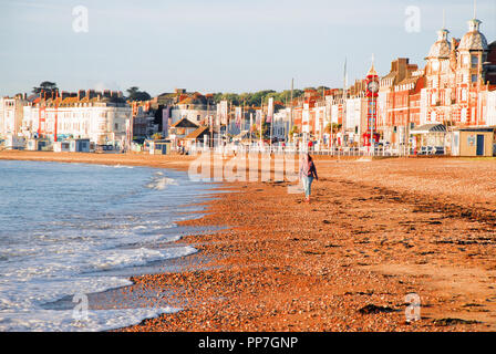 Weymouth. 24. September 2018. UK Wetter: eine Frau nimmt ein Spaziergang am sonnigen Strand von Weymouth, gut vor acht Uhr morgens Credit: stuart Hartmut Ost/Alamy leben Nachrichten Stockfoto