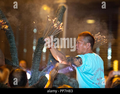 Hong Kong, Hong Kong, China. 24 Sep, 2018. Die jährlichen Tai Hang Fire Dragon Dance begrüßt in diesem Jahre Mitte Herbst Festival. Die Jahrhunderte alte, der mittlerweile als einer der immateriellen kulturellen Hong Kong's Erfahrungen aufgeführt, sieht eine 67 Meter lange Drachen, mit über 70.000 Räucherstäbchen von den Darstellern durch die engen Strassen getragen. Trommler und andere Darsteller die Massen zu unterhalten, während das Feuer drache aus Angst vor bösen Geistern. Credit: Jayne Russell/ZUMA Draht/Alamy leben Nachrichten Stockfoto