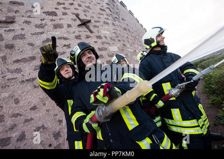 Eisenach, Thüringen. 24 Sep, 2018. Feuerwehrmänner stehen auf der Wartburg mit ihren Schläuchen. Eisenach Feuerwehren üben die Katastrophe und die neu entwickelte Gefahr Konzept auf der Wartburg in der Praxis. Die Wartburg, die zum UNESCO-Weltkulturerbe und mit seiner einzigartigen Kulturgüter und historische Gebäude, ist besonders schützenswert. Credit: Swen Pförtner/dpa/Alamy leben Nachrichten Stockfoto