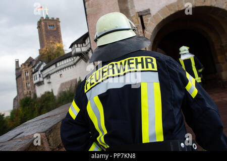 Eisenach, Thüringen. 24 Sep, 2018. Feuerwehrmänner Spaziergang über die Brücke zur Wartburg. Eisenach Feuerwehren üben die Katastrophe und die neu entwickelte Gefahr Konzept auf der Wartburg in der Praxis. Die Wartburg, die zum UNESCO-Weltkulturerbe und mit seiner einzigartigen Kulturgüter und historische Gebäude, ist besonders schützenswert. Credit: Swen Pförtner/dpa/Alamy leben Nachrichten Stockfoto