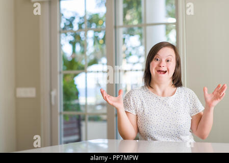 Down Syndrom Frau zu Hause sehr glücklich und aufgeregt, Sieger Ausdruck feiern Sieg schreien mit einem großen Lächeln und erhobenen Händen Stockfoto