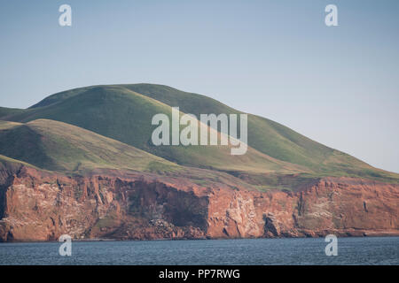 Grünen Hügeln Turm über den roten Sandsteinfelsen der Eintrag Insel im Magdalen Islands, Quebec, Kanada. Stockfoto