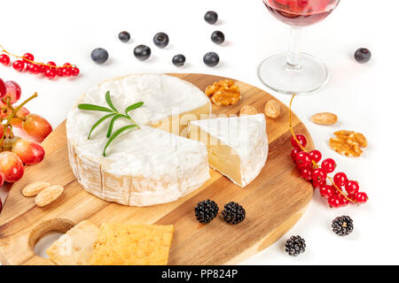 Ein Foto von Camembert mit einem Glas Rotwein, Obst und Nüsse, Schuß auf einen weißen Hintergrund mit Kopie Raum Stockfoto