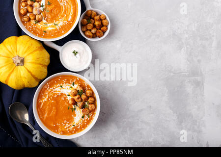 Karotte Kürbissuppe mit würzige Kichererbsen und Sesam auf grauem Stein Background Copy space Stockfoto