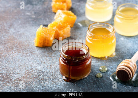 Honig, honig Pendelarm und Bienenwaben. Gesunde Lebensweise, gesunde Ernährung Produkten. Handwerk Honig in Gläsern Stockfoto