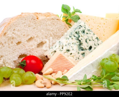 Verschiedene Arten von Käse und Beilagen auf Holzplatte Stockfoto