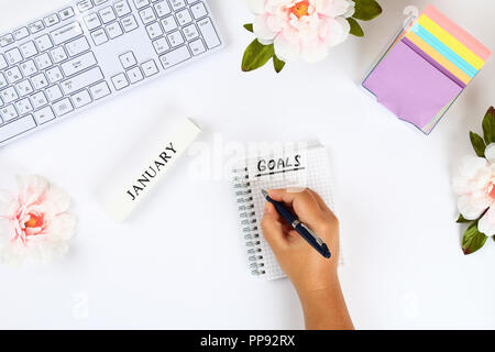 Ein Ziel für das neue Jahr 2010 in ein weißes Notebook auf einem weißen desktop Schreiben neben einer Kaffeetasse und einer Tastatur. Ansicht von oben, flach Layout Stockfoto