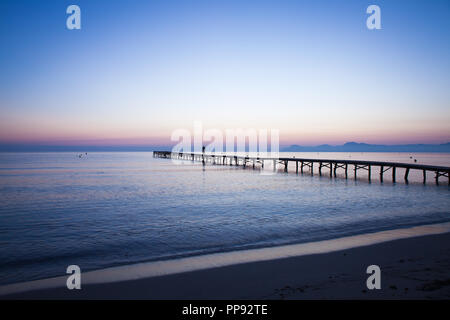 Europa Spanien Nord Mallorca Playa de Muro, langer Holzsteg in der Bucht von Alcudia bei Sonnenaufgang Stockfoto