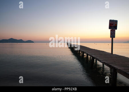 Europa Spanien Nord Mallorca Playa de Muro, langer Holzsteg in der Bucht von Alcudia bei Sonnenaufgang Stockfoto