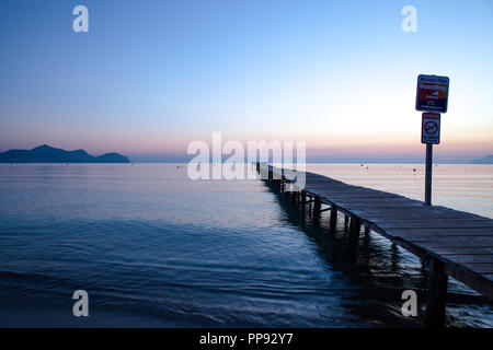 Europa Spanien Nord Mallorca Playa de Muro, langer Holzsteg in der Bucht von Alcudia bei Sonnenaufgang Stockfoto