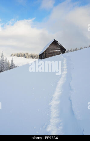 Winterlandschaft mit kleinen hölzernen Haus in den Bergen. Karpaten, Ukraine Stockfoto