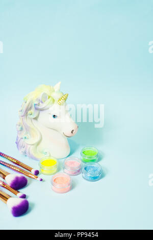 Leiter ein Einhorn und Glitzer Lidschatten auf blauem Hintergrund. Stockfoto