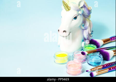 Leiter ein Einhorn und Glitzer Lidschatten auf blauem Hintergrund. Stockfoto