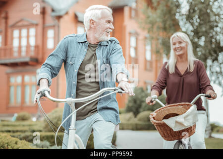 Positive freuen Paar mit ihren Fahrrädern beim Gehen Stockfoto