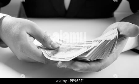 Schwarz-weiß-Bild des Geschäftsmannes Holding groß Geld in Händen Stapel Stockfoto