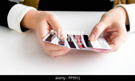 Closeup Bild von busineswoman sitzen hinter dem Schreibtisch und halten grosse von Kreditkarten Stapel Stockfoto