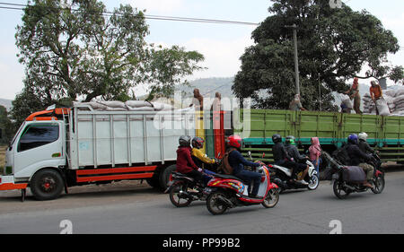 Arbeitnehmer bewegen Ladung von Lkw an andere Fahrzeuge in Bandung, Indonesien, Südostasien. Stockfoto