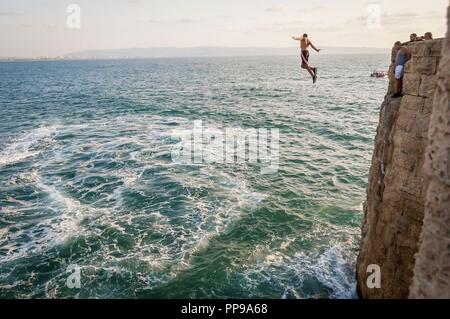 ACCO (ACRE), Israel. September 16, 2017. Junge arabische Männer springen ins Meer von der hohen Schutzmauer der antiken Acco. Unerschrockene junge Männer Stockfoto