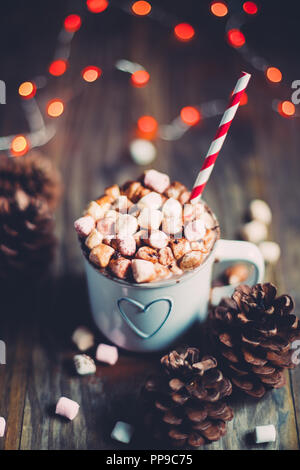 Weihnachten heiße Schokolade mit Marshmallows auf einem rustikalen Holztisch mit kiefernzapfen und rote Ampeln. Selektiver Fokus Stockfoto