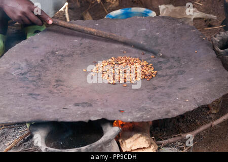 Eine Frau, die traditionelle Kaffee am offenen Feuer durch die Röstung der Kaffeebohnen, Äthiopien. Stockfoto