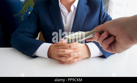 Closeup Bild von Hand Geld Stretching in Richtung Geschäftsmann im Büro stapeln Stockfoto