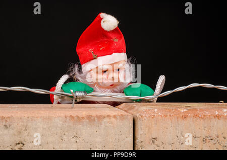 Santa Versuch, die Wand ein zuwanderungskonzept zu klettern Stockfoto