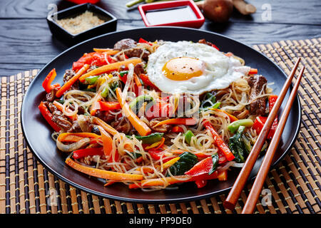 Koreanische japchae oder chapchae gebratene Nudeln mit Gemüse rühren: rote Paprika, Karotte, Shiitake-Pilze, grüne Zwiebeln, Knoblauch, Rindfleisch, Ei mit dressi Stockfoto