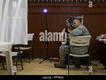 Us Air Force Maj. Derek Melton, ein Augenarzt die 181St Medical Group, Indiana Air National Guard zugeordnet, Kontrollen, in dem die Vision eines Patienten während Tropic Care Maui County 2018, Lanai City, Hi. August 11, 2018. Tropic Care Maui County 2018 bietet medizinische Service Mitglieder und praktische Unterstützung Personal" - "Readiness Training für zukünftige Bereitstellungen vorbereiten, während für direkte und dauerhafte Vorteile für die Bevölkerung von Maui, Molokai und Lanai, August 11-19. Stockfoto