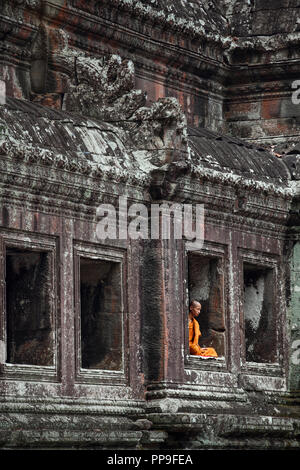 Buddhistischer Mönch meditieren im Fenster der Tempel in Angkor Wat, Siem Reap, Kambodscha Stockfoto