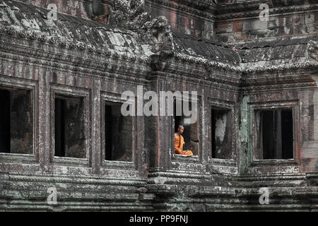 Buddhistischer Mönch meditieren im Fenster der Tempel in Angkor Wat, Siem Reap, Kambodscha Stockfoto