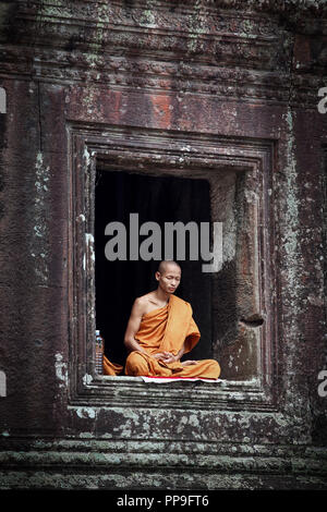 Buddhistischer Mönch meditieren im Fenster der Tempel in Angkor Wat, Siem Reap, Kambodscha Stockfoto