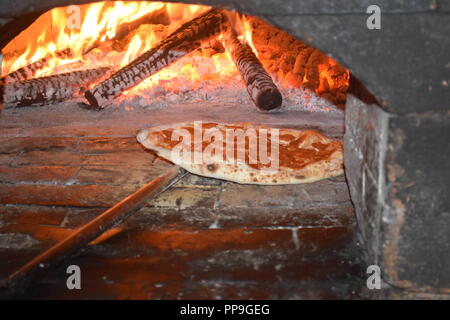 Original italienische Pizza frisch zubereitet und gebacken in einem traditionellen italienischen Holz Feuer Stein gemauerter Ofen ich ein Restaurant in Baguio City, Philippinen Stockfoto