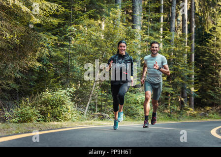 Paar, dass Draußen - zwei Athleten Training im Wald Stockfoto