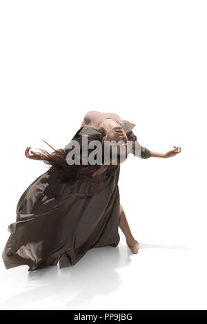 Schöne schlanke junge weibliche Modern Jazz modern Ballett Tänzerin in Silhouette tragen beige langen Umhang auf einem weißen studio Hintergrund isoliert Stockfoto