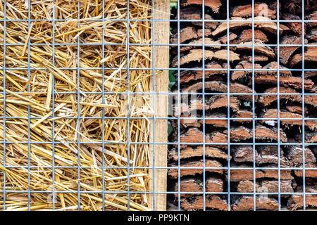 Close-up Teil des Handwerks Hotel oder Haus für Wilde Bienen und andere Insekten aus natürlichen umweltfreundlichen Materialien. Tierheim aus Kegel, Holz und Bambus, Heu, Stroh und Rinde Stockfoto