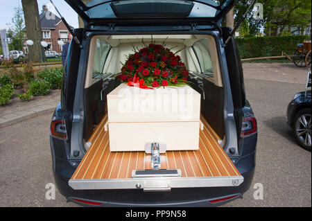 Ein Sarg mit einem Blumenarrangement in einem begräbnis Auto Stockfoto