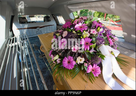 Ein Sarg mit einem Blumenarrangement in einem begräbnis Auto Stockfoto