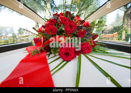 Ein Sarg mit einem Blumenarrangement in einem begräbnis Auto Stockfoto