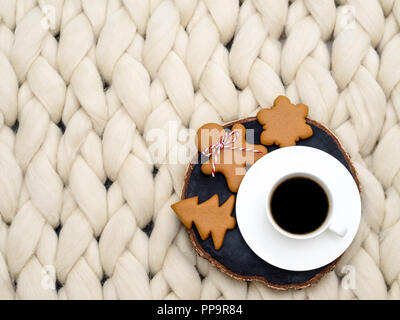 Gemütliche Zusammensetzung, closeup Merinowolle Decke, warme und komfortable Atmosphäre. Stricken Hintergrund. Tasse Kaffee und Ingwer Cookies. Weihnachten Konzept. Stockfoto