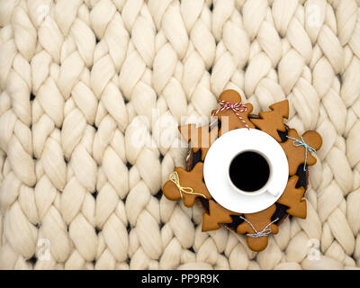 Gemütliche Zusammensetzung, closeup Merinowolle Decke, warme und komfortable Atmosphäre. Stricken Hintergrund. Tasse Kaffee und Ingwer Cookies. Weihnachten Konzept. Stockfoto