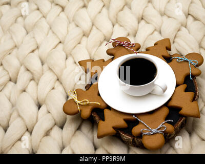 Gemütliche Zusammensetzung, closeup Merinowolle Decke, warme und komfortable Atmosphäre. Stricken Hintergrund. Tasse Kaffee und Ingwer Cookies. Weihnachten Konzept. Stockfoto