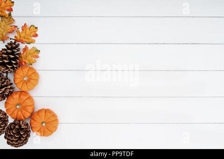 Rustikale Fallen der Blätter im Herbst, Tannenzapfen und mini Kürbisse mit kostenlosen Platz für Text über einem weißen Hintergrund im Landhausstil. Stockfoto