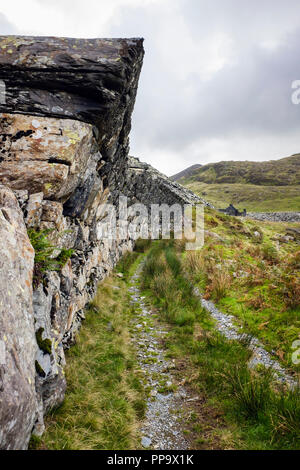 Überhängenden Wand über alte Straßenbahn-Linien in stillgelegten Schiefergrube Gorseddau in Snowdonia National Park. Cwmystradllyn Porthmadog Wales Gwynedd UK Großbritannien Stockfoto