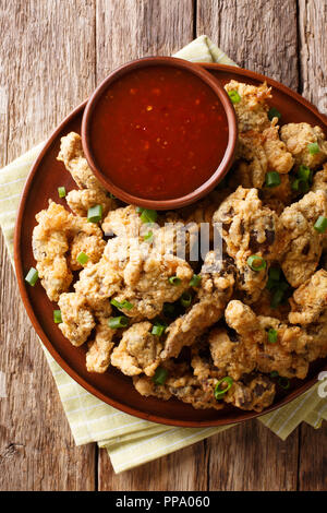 Fried Chicken Magen in paniert, mit Chili Sauce in der Nähe serviert auf einem Teller. Vertikal oben Ansicht von oben Stockfoto