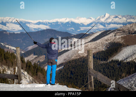 Wandern im Schnee mit Schneeschuhen mit Blick auf den schneebedeckten Gipfeln im Hintergrund. Stockfoto