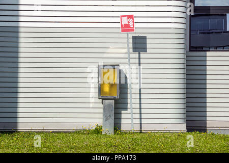 Red Fire Schlauchhaspel, die an der Wand Hintergrund montiert. Stockfoto