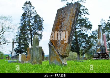 Sehr alte Moos bedeckt gebrochen Statue/Grabstein auf einem Friedhof Stockfoto