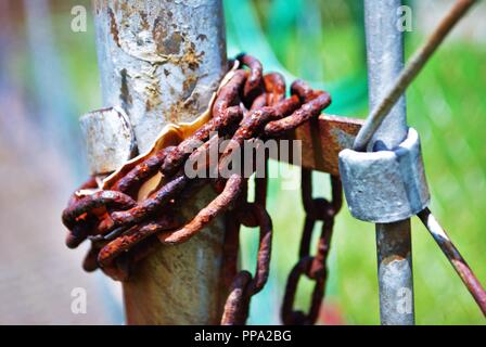 Rost bedeckt Schloss am Maschendrahtzaun Stockfoto