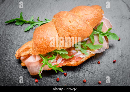 Frisches Croissant mit Schinken und Salat Blatt Stockfoto